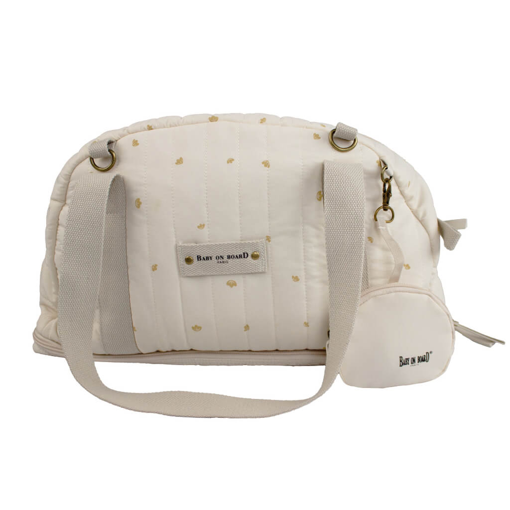 Sac à langer doudoune blanc crème Baby on Board avec détails dorés, un accessoire raffiné et fonctionnel pour les parents modernes.