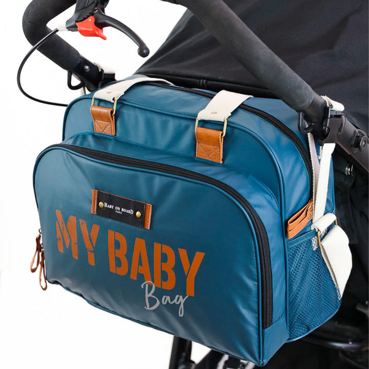 Sac Simply Baby Bag Ocean fixé à une poussette pour un transport pratique en déplacement.