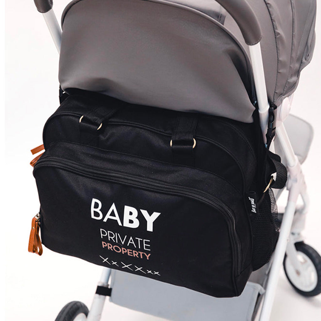 Sac à langer Simply Baby Private Property noir accroché à une poussette pour une organisation optimale.