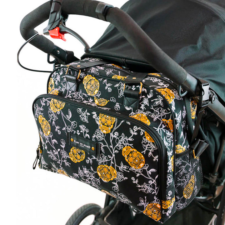 Sac à langer Simply Skull Look Baby on Board accroché à une poussette, parfait pour transporter l'essentiel de bébé en toute simplicité.